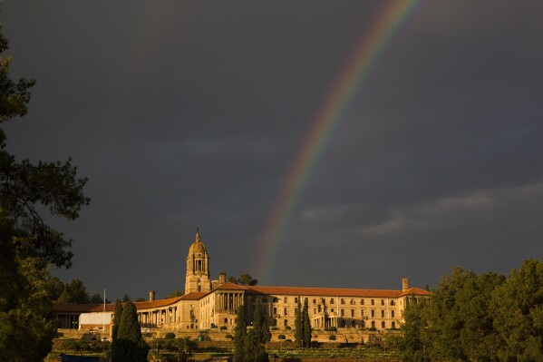 FILE- A rainbow forms over the Union Buildings in Pretoria, South Africa, Thursday, Dec. 12, 2013. (AP Photo/Matt Dunham, File)