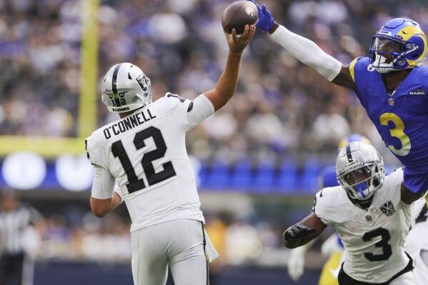 Las Vegas Raiders quarterback Aidan O'Connell (12) attempts to throw a pass as Los Angeles Rams safety Kamren Curl (3) jumps to defend during the first half of an NFL football game Sunday, Oct. 20, 2024, in Inglewood, Calif. (AP Photo/Ryan Sun)