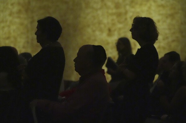 Worshipers stand to say the names of loved ones in need of prayers during a Shabbat service, Friday, Sept. 27, 2024, at Temple Beth Sholom in Miami Beach, Fla. (AP Photo/Wilfredo Lee)