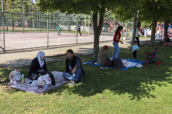 People rest in a public park outdoors away from buildings following an earthquake in Malatya, southern Turkey, Wednesday, Oct. 16, 2024. (Burhan Karaduman/Dia Photo via AP)