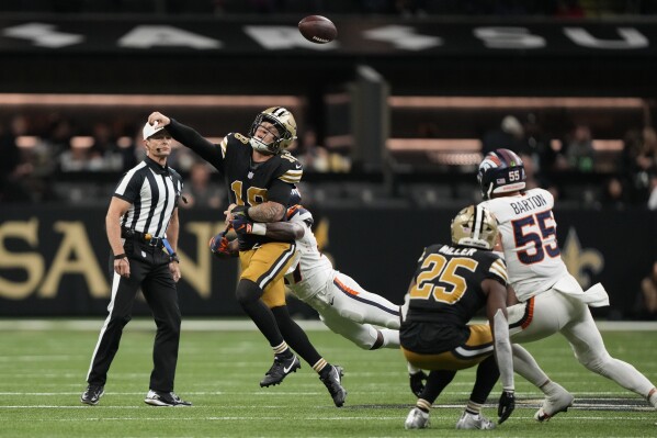 New Orleans Saints quarterback Spencer Rattler (18) loses the ball as he is hit by Denver Broncos cornerback Ja'Quan McMillian on a fumble returned for a touchdown by linebacker Cody Barton (55) in the second half of an NFL football game against the Denver Broncos in New Orleans, Thursday, Oct. 17, 2024. The Broncos won 33-10. (AP Photo/Gerald Herbert)