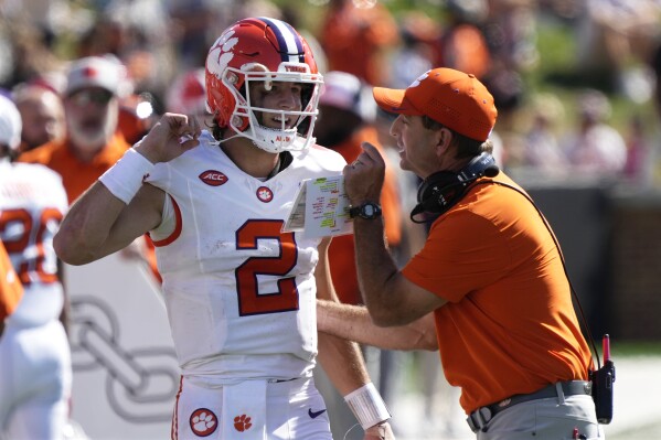 Clemson head coach Dabo Swinney, right, talks with quarterback Cade Klubnik (2) during the first half of an NCAA football game against Wake Forest in Greensboro, N.C., Saturday, Oct. 12, 2024. (AP Photo/Chuck Burton)