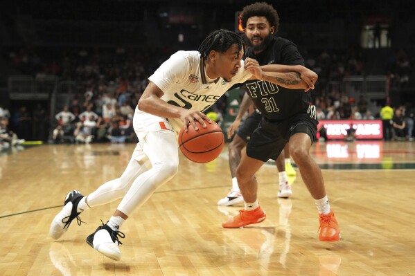 FILE - Miami guard Nijel Pack drives past Florida International guard George Pridgett Jr. (31) during the first half of an NCAA college basketball game, Nov. 13, 2023, in Coral Gables, Fla. (AP Photo/Jim Rassol, File)