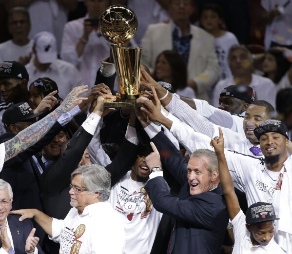 FILE - Miami Heat president Pat Riley points at the Larry O'Brien NBA Trophy after winning Game 7 of the NBA basketball championships, June 21, 2013, in Miami. (AP Photo/Wilfredo Lee, file)