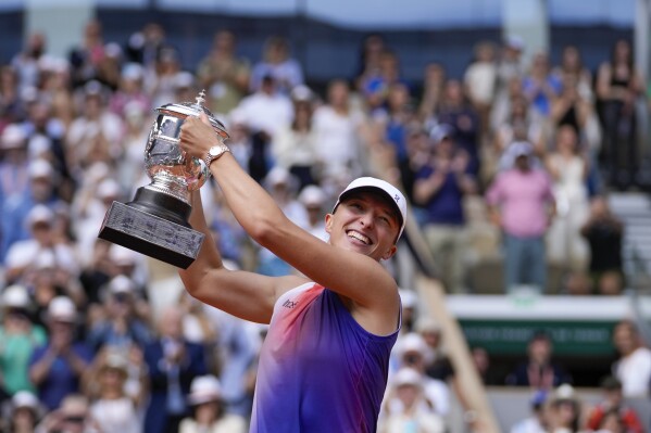 Poland's Iga Swiatek holds the trophy after winning the women's final of the French Open tennis tournament against Italy's Jasmine Paolini at the Roland Garros stadium in Paris, France, Saturday, June 8, 2024. (AP Photo/Thibault Camus)