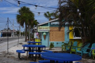 FILE - A boarded up business stands beside a deserted street in an evacuation zone, ahead of the arrival of Hurricane Milton, in Anna Maria, Fla., on Anna Maria Island, Oct. 8, 2024. (AP Photo/Rebecca Blackwell, File)