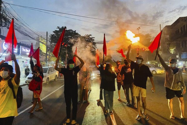 Pro-democracy protesters hold torches and flags during a flash mob rally to protest against Myanmar's military-government in Yangon, Myanmar on Sept.19, 2024. (Anti-Junta Alliance Yangon via AP)