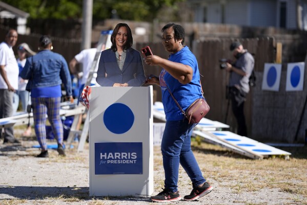 Arlett Brooks, of Omaha, Neb., takes a selfie with a cutout of Democratic presidential nominee Vice President Kamala Harris during a blue dot campaign sign get-together, Tuesday, Sept. 24, 2024, in Omaha, Neb. The blue dot signs, spotted throughout Omaha, represent Democratic-voting households in a state surrounded by Republican red. (AP Photo/Charlie Neibergall)