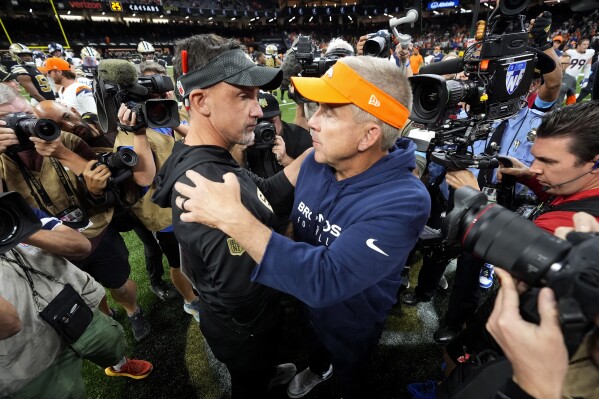 New Orleans Saints head coach Dennis Allen, left, talks with Denver Broncos head coach Sean Payton after an NFL football game, Thursday, Oct. 17, 2024, in New Orleans. The Broncos won 33-10. (AP Photo/Gerald Herbert)