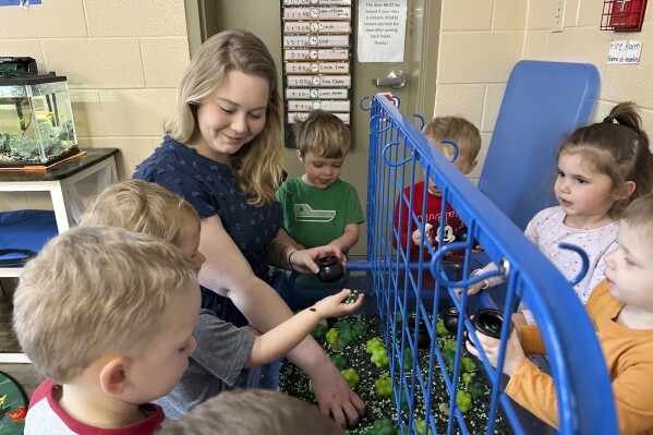 FILE - Rylee Monn plays with children in her class at a child care center in Lexington, Ky., March 13, 2024. (AP Photo/Dylan Lovan, File)