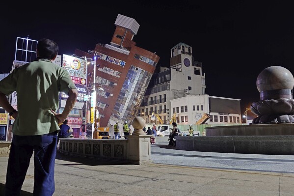 A man looks at the cordoned off site of a leaning building in the aftermath of an earthquake in Hualien, eastern Taiwan on Wednesday, April 3, 2024. Taiwan's strongest earthquake in a quarter century rocked the island during the morning rush hour Wednesday, damaging buildings and highways (AP Photo/Chiang Ying-ying)