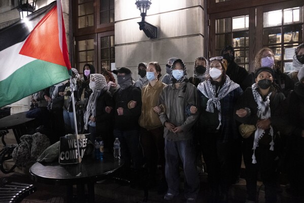 Pro Palestinian students lock arms, sing and chant as they braced for New York Police Department officers to raid campus after Columbia University President Minouche Shafik called on the NYPD to dismantle encampments and remove individuals from Hamilton Hall, Tuesday, April 30, 2024 in New York. (Seyma Bayram via AP)