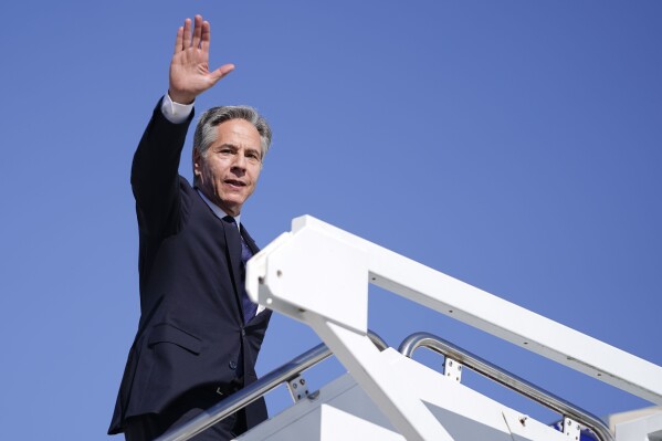 Secretary of State Antony Blinken waves as he boards a plane en route to the Middle East as he departs Joint Base Andrews, Md., Monday, Oct. 21, 2024. (Nathan Howard/Pool Photo via AP)