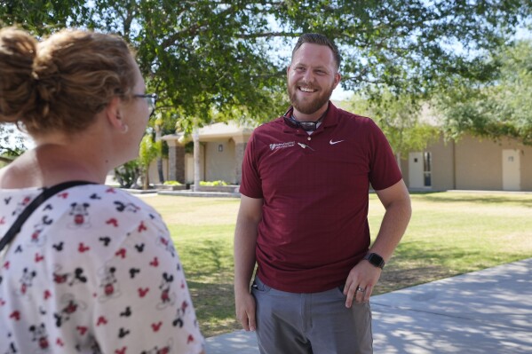 Trevor Cowling speaks with a parishioner at Valley Baptist Church, Tuesday, June 18, 2024, in Mesa, Ariz. (AP Photo/Ross D. Franklin)