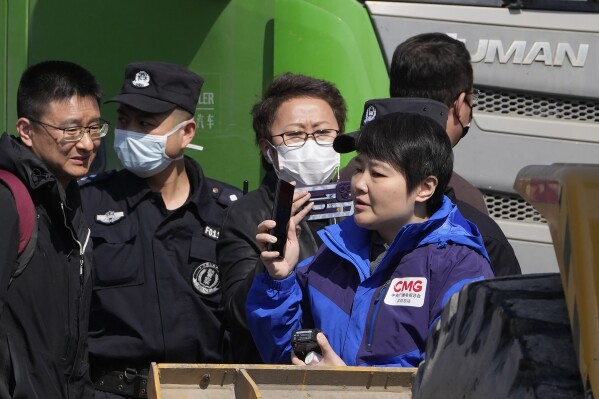 Chinese security personnel attempt to push Chinese journalists from the scene of an explosion in Sanhe city in northern China's Hebei province on Wednesday, March 13, 2024. City officials in eastern China have apologized to local journalists after authorities were shown pushing them and trying to obstruct reporting from the site of a deadly explosion, in a rare acknowledgment of state aggression against journalists. (AP Photo/Ng Han Guan)