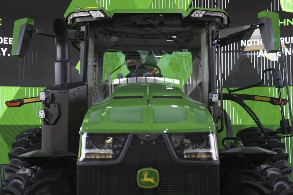 FILE - An attendee looks at a John Deere automated tractor at the John Deere booth during the CES tech show on Jan. 5, 2022, in Las Vegas. Deere & Co. confirmed Monday, July 1, 2024, that it's laying off nearly 600 workers as the farm equipment manufacturer deals with declining demand. (AP Photo/Joe Buglewicz)