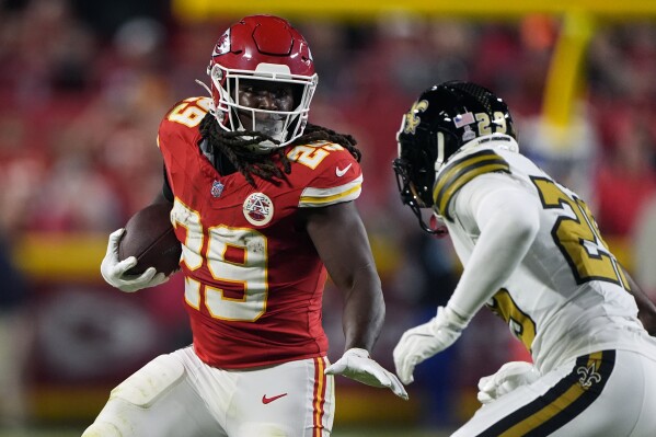 Kansas City Chiefs running back Kareem Hunt (29) runs with the ball as New Orleans Saints cornerback Paulson Adebo (29) defends during the first half of an NFL football game Monday, Oct. 7, 2024, in Kansas City, Mo. (AP Photo/Charlie Riedel)