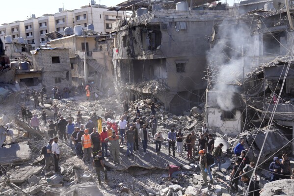 Rescatistas buscan víctimas en el lugar donde ataques aéreos israelíes destruyeron edificios próximos al principal hospital público de la capital, ubicado en un vecindario densamente poblado del sur de Beirut, Líbano, el 22 de octubre de 2024. (AP Foto/Hussein Malla)