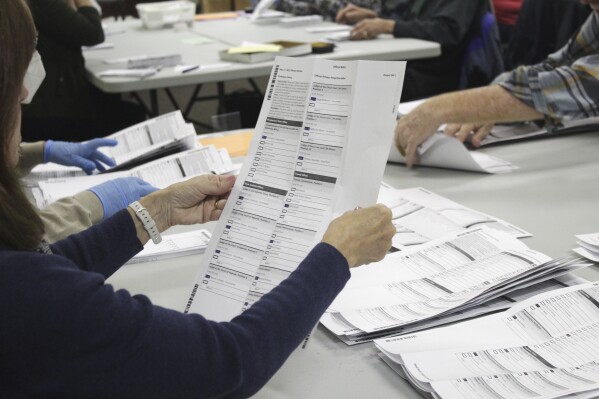 FILE - An election worker examines a ballot at the Clackamas County Elections office May 19, 2022, Oregon City, Ore. (AP Photo/Gillian Flaccus, File)