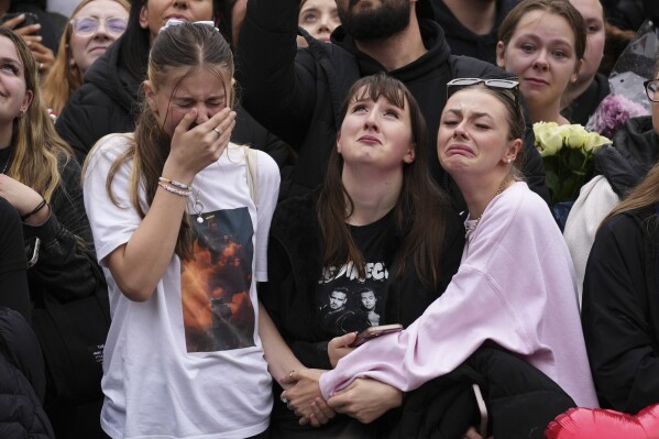 Fans react as they gather near the Peter Pan statue in Hyde Park, London to pay tribute to late British singer Liam Payne, former member of the British pop band One Direction, Sunday, Oct. 20, 2024. (Photo by Scott A Garfitt/Invision/AP)