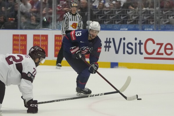 FILE - Unted States' Johnny Gaudreau, right, challenges for a puck with Latvia's Janis Jaks during the preliminary round match between Latvia and United States at the Ice Hockey World Championships in Ostrava, Czech Republic, Tuesday, May 21, 2024. (AP Photo/Darko Vojinovic, file)