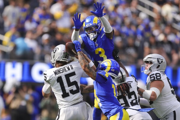 Los Angeles Rams cornerback Cobie Durant (14) forces a fumble against Las Vegas Raiders quarterback Gardner Minshew (15) as Rams safety Kamren Curl (3) jumps to defend during the first half of an NFL football game Sunday, Oct. 20, 2024, in Inglewood, Calif. (AP Photo/Ryan Sun)