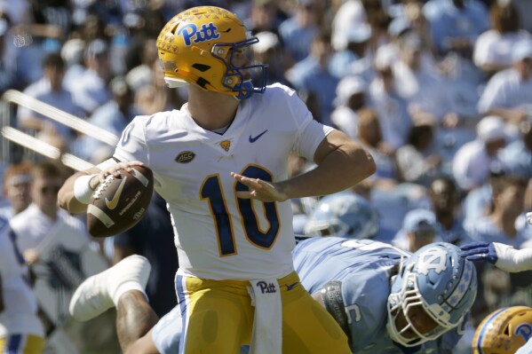 Pittsburgh quarterback Eli Holstein (10) looks to pass as he is pressured by North Carolina defensive lineman Joshua Harris (6) during the first half of an NCAA college football game Saturday, Oct. 5, 2024, in Chapel Hill, N.C. (AP Photo/Chris Seward)