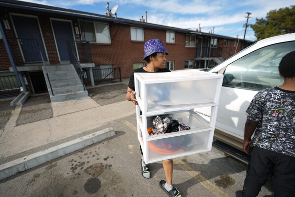 Monique Gant moves belongings out of an apartment after being evicted, Wednesday, Jan. 31, 2024, in Westminster, Colo. Monthly rent has outpaced income across the U.S., and forced many to make tough decisions between everyday necessities and a home. In turn, a record number of people are becoming homeless and evictions filings have ratcheted up as pandemic-era eviction moratoriums and federal assistance ends. (AP Photo/David Zalubowski)