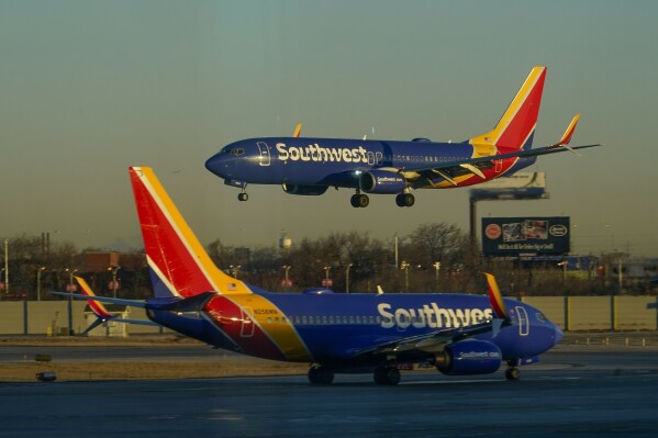 FILE - A Southwest Airlines plane prepares to land at Midway International Airport while another taxis on the ground, Feb. 12, 2023, in Chicago. (AP Photo/Kiichiro Sato, File)