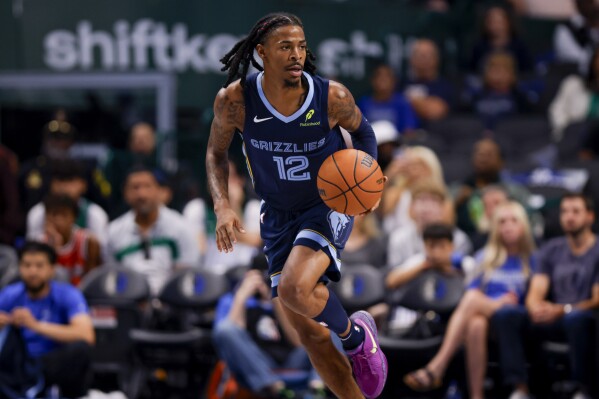 Memphis Grizzlies guard Ja Morant brings the ball down court during the first half of an NBA preseason basketball game against the Dallas Mavericks in Dallas, Monday, Oct. 7, 2024. (AP Photo/Gareth Patterson)