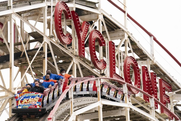 FILE - People ride the Coney Island Cyclone roller coaster, April 9, 2021, in the Brooklyn borough of New York. (AP Photo/John Minchillo, File)