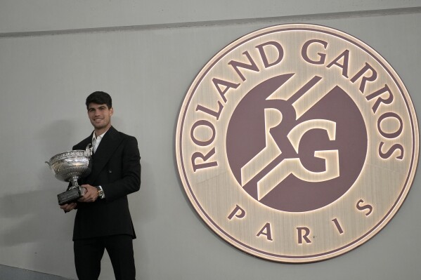 Spain's Carlos Alcaraz holds the trophy as he poses for media after the French Open tennis tournament at the Roland Garros stadium in Paris, Monday, June 10, 2024. Alcaraz won the title on Sunday in the final against Germany's Alexander Zverev. (AP Photo/Christophe Ena)