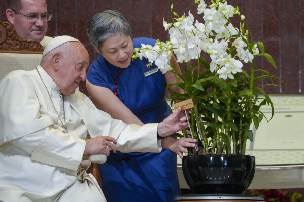 Chief Executive Officer of the Singapore's National Parks Board Hwang Yu-Ning presents Pope Francis with a 'Dendrobium His Holiness Pope Francis', a specially bred orchid variety named after him at the Parliament House in Singapore, Thursday, Sept. 12, 2024. Pope Francis flew to Singapore on Wednesday for the final leg of his trip through Asia, arriving in one of the world's richest countries from one of its poorest after a record-setting final Mass in East Timor. (AP Photo/Gregorio Borgia)