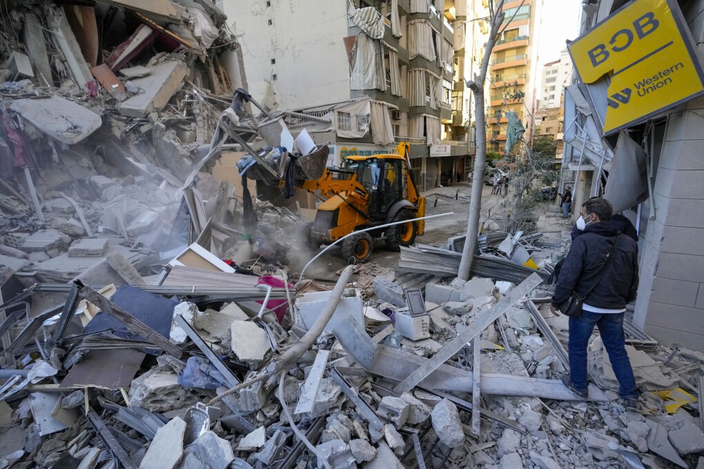 Rescatistas utilizan una excavadora para retirar escombros de edificios destruidos en el lugar de un ataque aéreo israelí el domingo por la noche que golpeó varias oficinas de la entidad financiera gestionada por Hezbollah-run Al-Qard Al-Hassan en un suburbio sureño de Beirut, Líbano, el lunes 21 de octubre de 2024. (AP Foto/Hassan Ammar)