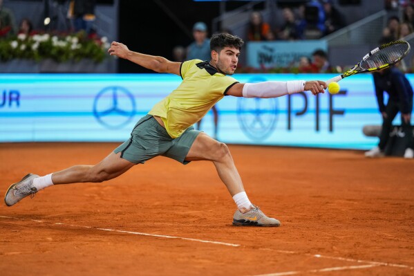 Carlos Alcaraz, of Spain, returns the ball to Andrey Rublev, of Russia, during the Mutua Madrid Open tennis tournament in Madrid, Wednesday, May 1, 2024. (AP Photo/Manu Fernandez)