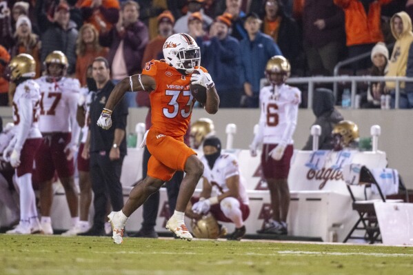 Virginia Tech's Bhayshul Tuten (33) runs for a touchdown against Boston College during the second half of an NCAA college football game, Thursday, Oct. 17, 2024, in Blacksburg, Va. (AP Photo/Robert Simmons)