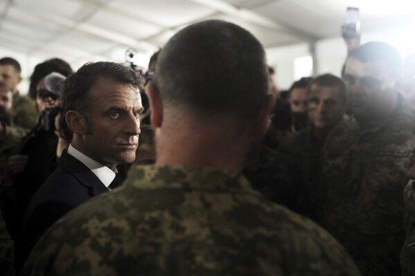 French President Emmanuel Macron, front left, speaks with Ukrainian soldiers in a military camp in eastern France, Wednesday, Oct. 9, 2024. (AP Photo/Thibault Camus, Pool)