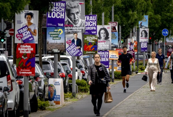 People walk past elections posters for the European elections in Frankfurt, Germany, Thursday, June 6, 2024. (AP Photo/Michael Probst)