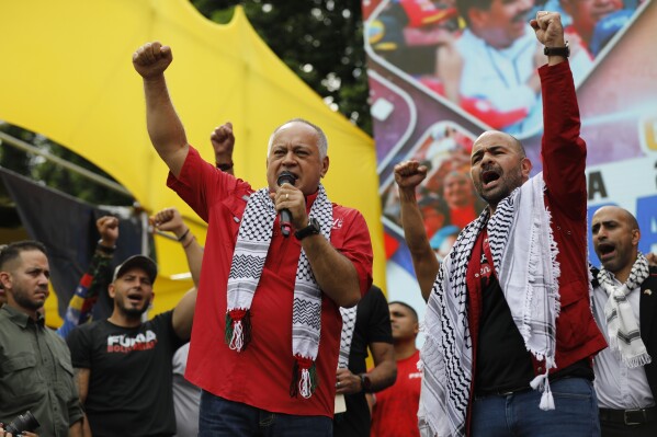 Venezuelan Interior Minister Diosdado Cabello, left, and Palestinian Ambassador to Venezuela Maher Taha, take part in a rally celebrating the July 28 reelection of President Nicolas Maduro, in Caracas, Venezuela, Saturday, Sept. 28, 2024. (AP Photo/Cristian Hernandez)