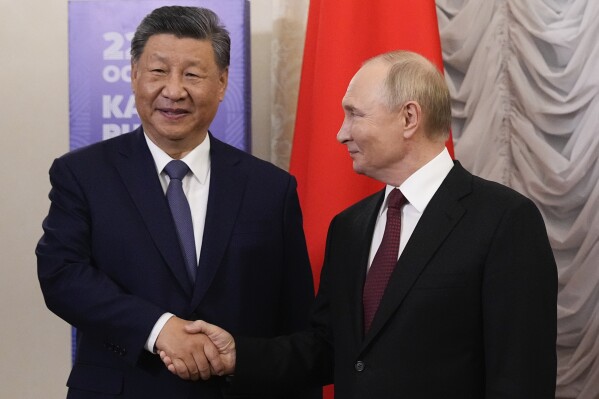 Russian President Vladimir Putin, right, and Chinese President Xi Jinping shake hands during their meeting on the sidelines of BRICS Summit at Kazan Kremlin in Kazan, Russia, Tuesday, Oct. 22, 2024. (AP Photo/Alexander Zemlianichenko, Pool)