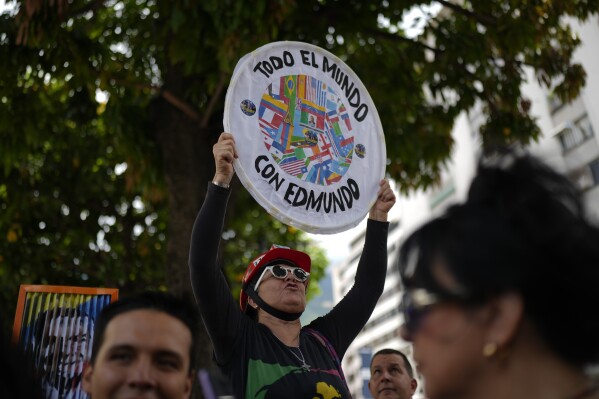 A woman holds up a sign with a message that reads in Spanish: "Everyone with Edmundo" during a protest against the reelection of President Nicolás Maduro two month after the disputed presidential vote which opposition leaders say they won by a landslide in Caracas, Venezuela, Saturday, Sept. 28, 2024. (AP Photo/Ariana Cubillos)