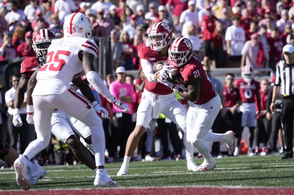 Indiana's Tayven Jackson, left, hands off to running back Elijah Green during the second half of an NCAA college football game in Bloomington, Ind., Saturday, Oct. 19, 2024. (AP Photo/AJ Mast)