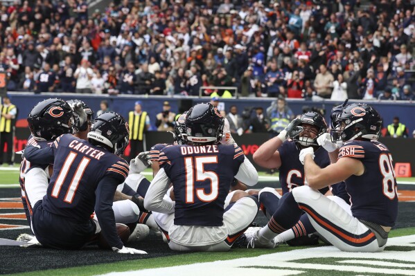 Bears players celebrate after Chicago Bears wide receiver Keenan Allen (13) scored his side's third touchdown during the third quarter of an NFL football game at the Tottenham Hotspur stadium between the Jacksonville Jaguars and Chicago Bears in London, Sunday, Oct. 13, 2024. (AP Photo/Ian Walton)