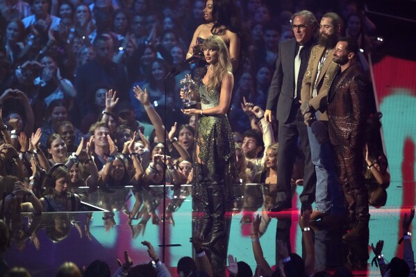 Taylor Swift, center, and Post Malone, third from back left, accept the video of the year award for "Fortnight" during the MTV Video Music Awards on Wednesday, Sept. 11, 2024, at UBS Arena in Elmont, N.Y. Host Megan Thee Stallion, from far left back, Rodrigo Prieto, and Ethan Tobman, far right, look on. (Photo by Charles Sykes/Invision/AP)