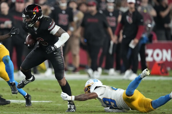 Arizona Cardinals running back James Conner (6) runs from Los Angeles Chargers cornerback Tarheeb Still (29) during the second half of an NFL football game, Monday, Oct. 21, 2024, in Glendale Ariz. (AP Photo/Matt York)