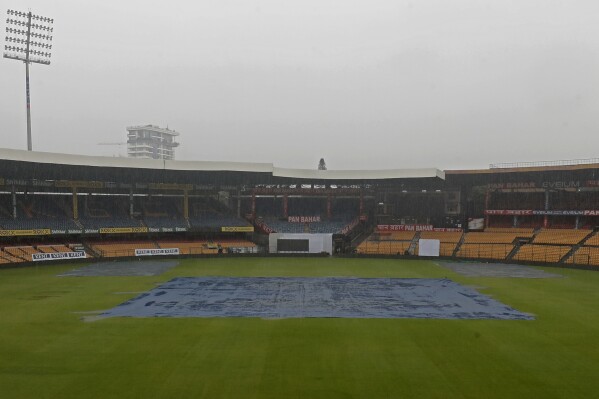 The pitch area is covered with plastic sheets as it rains on the eve of the first cricket test match between India and New Zealand at the M.Chinnaswamy Stadium, in Bengaluru, India, Tuesday, Oct. 15, 2024. (AP Photo/Surjeet Yadav)