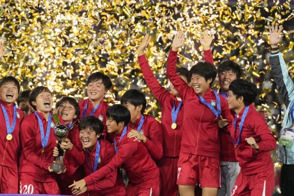 North Korean players celebrate with the trophy after winning the U-20 Women's World Cup final soccer match against Japan at El Campin stadium in Bogota, Colombia, Sunday, Sept. 22, 2024.(AP Photo/Fernando Vergara)