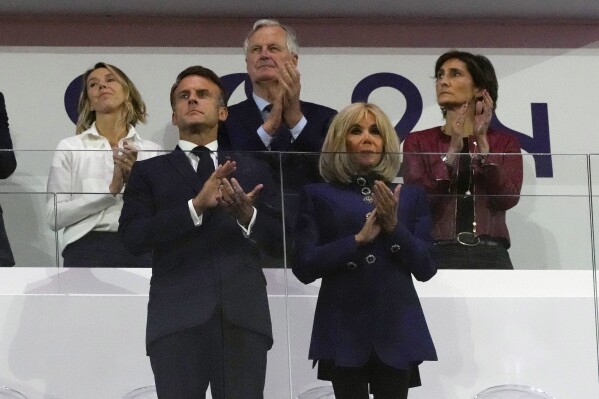 FILE - French Prime Minister Michel Barnier, background center, French President Emmanuel Macron, foreground left, and Macron's wife, Brigitte Macron, foreground right, applaud during the closing ceremony of the 2024 Paralympics, Sunday, Sept. 8, 2024, in Paris, France. (AP Photo/Michel Euler, File)