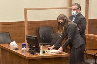 FILE - Former Ohio police officer Adam Coy stands during a Franklin County hearing as defense attorney Kaitlyn Stephens checks her notes, Oct. 4, 2021, in Columbus, Ohio. (AP Photo/Andrew Welsh-Huggins, File)