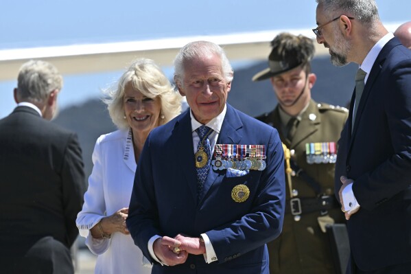 Britain's King Charles III, center, and Queen Camilla arrive at Defense Establishment Fairbairn in Canberra, Australia, Monday, Oct. 21, 2024. (Saeed Khan/Pool Photo via AP)